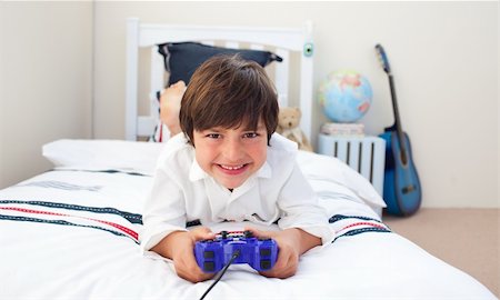 simsearch:400-04200290,k - Cute little boy playing video games in his bedroom Stock Photo - Budget Royalty-Free & Subscription, Code: 400-04196946
