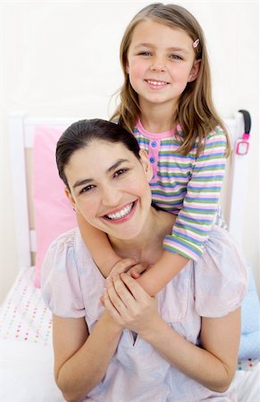 simsearch:400-05749479,k - Smiling little girl hugging her mother on a bed Foto de stock - Royalty-Free Super Valor e Assinatura, Número: 400-04196943