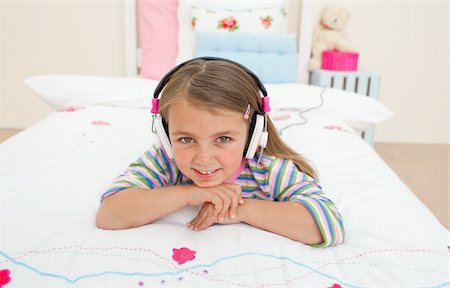 simsearch:400-05717354,k - Cute little gril listening to music lying on her bed Stock Photo - Budget Royalty-Free & Subscription, Code: 400-04196978