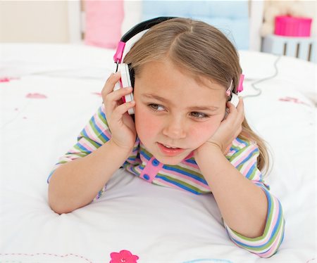 simsearch:400-05717354,k - Adorable gril listening to music with headphones lying on her bed Stock Photo - Budget Royalty-Free & Subscription, Code: 400-04196984