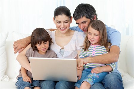 Jolly family using a laptop on the sofa at home Stock Photo - Budget Royalty-Free & Subscription, Code: 400-04196986