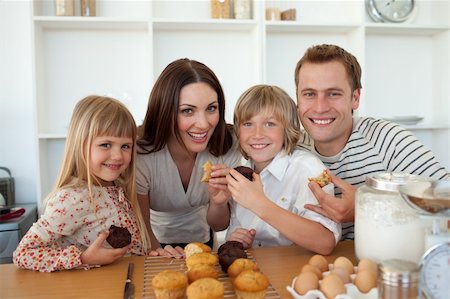 Cute children eating muffins with their parents in the kitchen Stock Photo - Budget Royalty-Free & Subscription, Code: 400-04197036