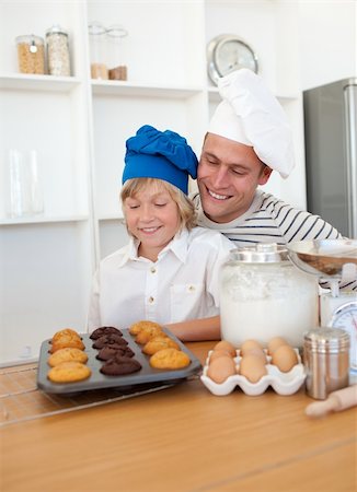 Charming father and his son presenting their muffins in the kitchen Stock Photo - Budget Royalty-Free & Subscription, Code: 400-04197037