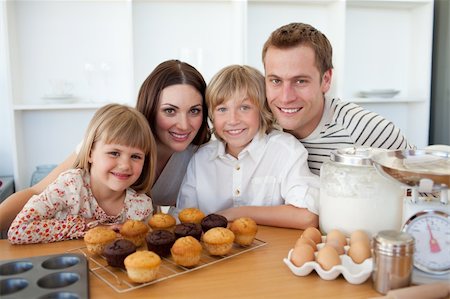 Happy family presenting their muffins in the kitchen Stock Photo - Budget Royalty-Free & Subscription, Code: 400-04197042