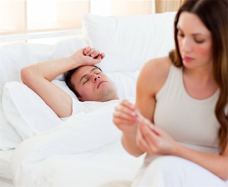 Concerned woman taking her sick husband's temperature in their bedroom Stock Photo - Budget Royalty-Free & Subscription, Code: 400-04197059