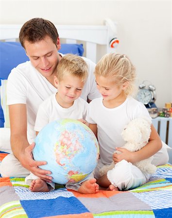 Cute siblings and their father looking at a terrestrial globe sitting on bed Stock Photo - Budget Royalty-Free & Subscription, Code: 400-04197062