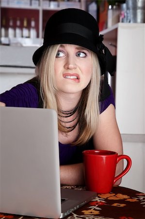 simsearch:400-04554624,k - Worried blond girl with laptop and mug at a cafe Stock Photo - Budget Royalty-Free & Subscription, Code: 400-04197179