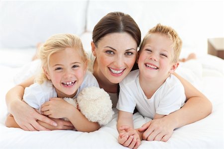 simsearch:400-05749479,k - Portrait of a happy mother and her children lying on a bed Foto de stock - Royalty-Free Super Valor e Assinatura, Número: 400-04197267