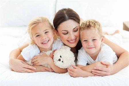 simsearch:400-05749479,k - Portrait of a cheerful children with their mother lying on a bed Foto de stock - Royalty-Free Super Valor e Assinatura, Número: 400-04197268