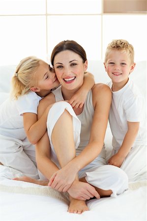 simsearch:400-04196942,k - Cute children kissing their mother sitting on a bed at home Photographie de stock - Aubaine LD & Abonnement, Code: 400-04197276