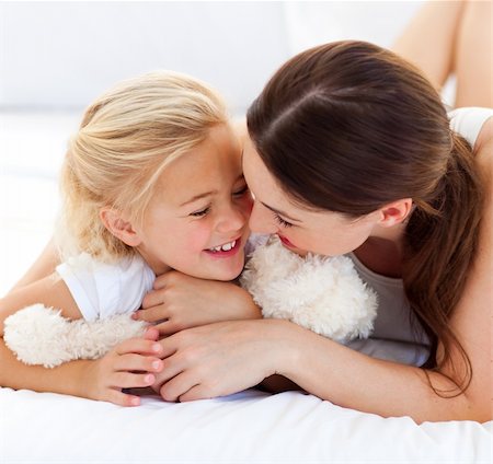 simsearch:400-05749479,k - Attentive mother hugging her daughter lying on a bed Foto de stock - Royalty-Free Super Valor e Assinatura, Número: 400-04197277