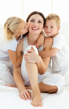 simsearch:400-05749479,k - Lively siblings hugging their mother sitting on a bed at home Foto de stock - Royalty-Free Super Valor e Assinatura, Número: 400-04197279