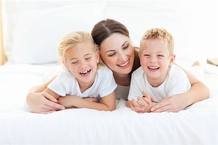 simsearch:400-05749479,k - Happy siblings playing with their mother lying on a bed at home Foto de stock - Royalty-Free Super Valor e Assinatura, Número: 400-04197270