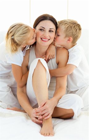 simsearch:400-05749479,k - Jolly siblings kissing their mother sitting on a bed at home Foto de stock - Royalty-Free Super Valor e Assinatura, Número: 400-04197280