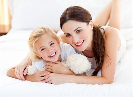 simsearch:400-04196942,k - Portrait of a smiling mother and her little girl lying on the bed Photographie de stock - Aubaine LD & Abonnement, Code: 400-04197292