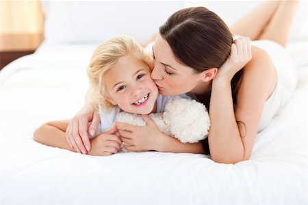 simsearch:400-05749479,k - Attractive mother kissing her little girl lying on a bed Foto de stock - Royalty-Free Super Valor e Assinatura, Número: 400-04197300