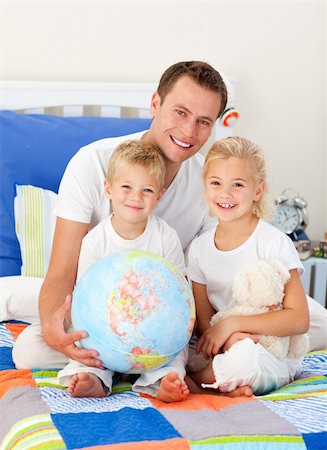 Cute children and their father looking at a terrestrial globe sitting on bed Stock Photo - Budget Royalty-Free & Subscription, Code: 400-04197347