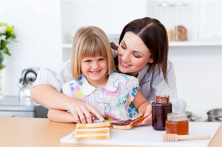 simsearch:400-04206231,k - Smiling little girl and her mother preparing toasts in the kitchen Stock Photo - Budget Royalty-Free & Subscription, Code: 400-04197458