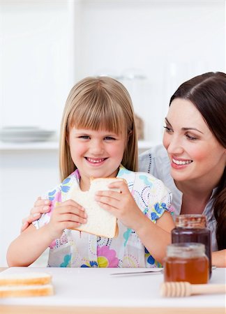 simsearch:400-04206231,k - Happy little girl and her mother eating slices of bread in the kitchen Stock Photo - Budget Royalty-Free & Subscription, Code: 400-04197460