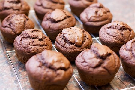 Twelve freshly baked chocolate muffins cooling off on wire mesh Foto de stock - Super Valor sin royalties y Suscripción, Código: 400-04197496