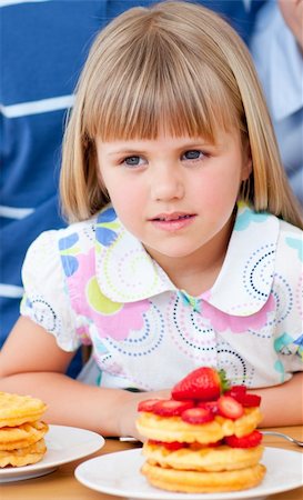 Cute little girl eating waffles with strawberries in the kitchen Stock Photo - Budget Royalty-Free & Subscription, Code: 400-04197520