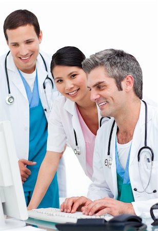 Positive medical team working at a computer against a white background Stock Photo - Budget Royalty-Free & Subscription, Code: 400-04197685