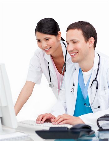 Two happy doctors working at a computer against a white background Stock Photo - Budget Royalty-Free & Subscription, Code: 400-04197694