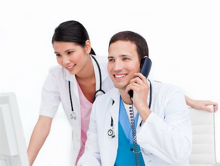 Two happy doctors talking on phone against a white background Stock Photo - Budget Royalty-Free & Subscription, Code: 400-04197705