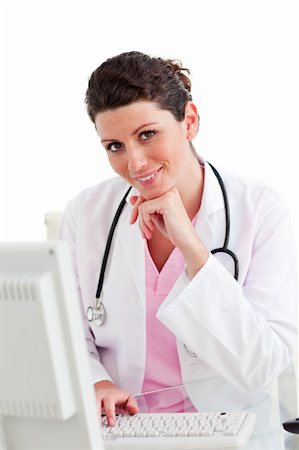 simsearch:400-04704005,k - Smiling female doctor working at a computer against a white background Stock Photo - Budget Royalty-Free & Subscription, Code: 400-04197711