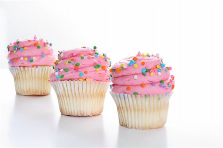 simsearch:400-04178778,k - Three cupcakes with sprinkles in a line isolated on white Foto de stock - Super Valor sin royalties y Suscripción, Código: 400-04197953
