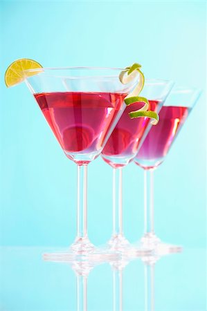 Stock image of three Cosmopolitan cocktails over blue background with reflection on bottom. Selective focus on front glass. Find more prepared drinks and cocktails in my portfolio. Stock Photo - Budget Royalty-Free & Subscription, Code: 400-04198103