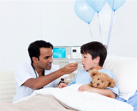 Attentive doctor giving medicine to a little boy at the hospital Stockbilder - Microstock & Abonnement, Bildnummer: 400-04198323