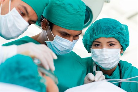 simsearch:400-04699159,k - Confident surgeons during a surgery in the hospital Stock Photo - Budget Royalty-Free & Subscription, Code: 400-04198386