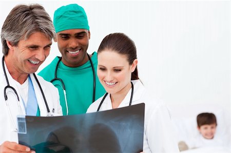 Medical team examining an x-ray and a little boy recovering in bed Stock Photo - Budget Royalty-Free & Subscription, Code: 400-04198488