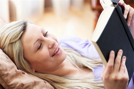 simsearch:400-04905604,k - Jolly woman reading a book lying on a sofa in a living-room Stockbilder - Microstock & Abonnement, Bildnummer: 400-04198600