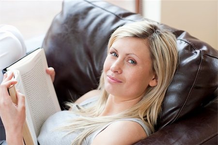 simsearch:400-04905604,k - Charming woman reading a book sitting on a sofa in a living-room Stockbilder - Microstock & Abonnement, Bildnummer: 400-04198603