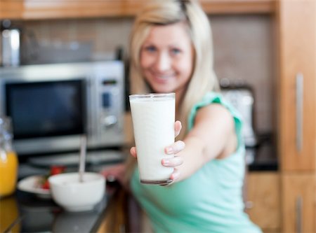 simsearch:400-04708507,k - Happy woman holding a glass of milk while having an healthy breakfast in a kitchen Stock Photo - Budget Royalty-Free & Subscription, Code: 400-04198634