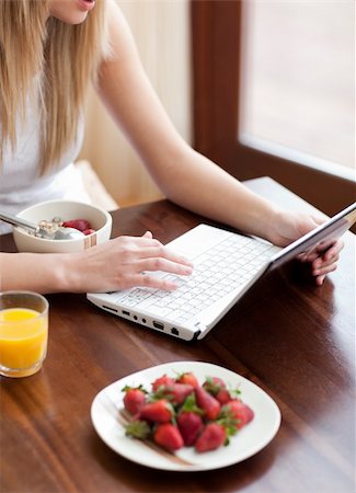 simsearch:400-04708507,k - Blond woman using a laptop while having breakfast at home Stock Photo - Budget Royalty-Free & Subscription, Code: 400-04198664