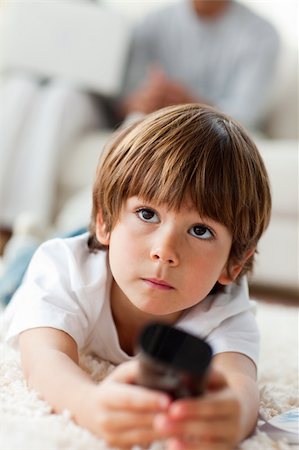 family floor tv - Little boy watching TV lying on the floor in the living-room at home Stock Photo - Budget Royalty-Free & Subscription, Code: 400-04198760