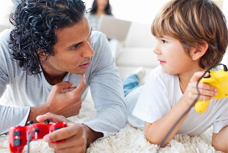 simsearch:400-04199147,k - Father and his little boy playing video games lying on the floor in the living-room Foto de stock - Royalty-Free Super Valor e Assinatura, Número: 400-04198780