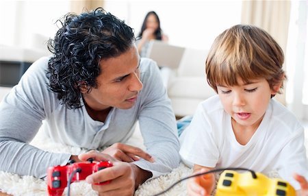 simsearch:400-04199147,k - Father and his son playing video games lying on the floor in the living-room Photographie de stock - Aubaine LD & Abonnement, Code: 400-04198781