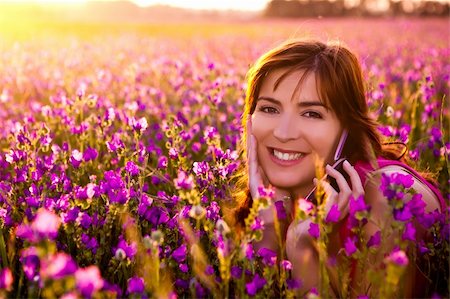 Beautiful young woman lying on the nature and talking at cellphone Stock Photo - Budget Royalty-Free & Subscription, Code: 400-04198824