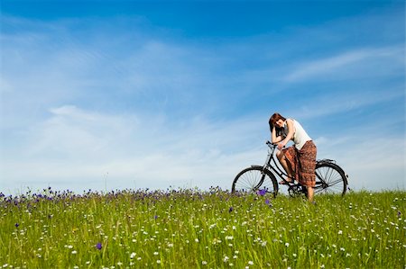 simsearch:400-04201795,k - Happy young woman with a vintage bicycle on a green meadow Fotografie stock - Microstock e Abbonamento, Codice: 400-04198830