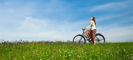 simsearch:400-04201795,k - Happy young woman with a vintage bicycle on a green meadow Fotografie stock - Microstock e Abbonamento, Codice: 400-04198831