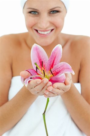 simsearch:400-05663148,k - Smiling woman holding a flower against a white background Photographie de stock - Aubaine LD & Abonnement, Code: 400-04198887