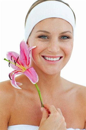 simsearch:400-05663148,k - Delighted woman holding a flower against a white background Photographie de stock - Aubaine LD & Abonnement, Code: 400-04198882