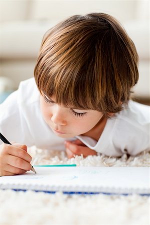 Little boy drawing lying on the floor in the living-room at home Stock Photo - Budget Royalty-Free & Subscription, Code: 400-04199078