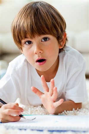 daycare on floor - Animated little boy drawing lying on the floor in the living-room Stock Photo - Budget Royalty-Free & Subscription, Code: 400-04199079