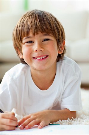 daycare on floor - Happy little boy drawing lying on the floor in the living-room Stock Photo - Budget Royalty-Free & Subscription, Code: 400-04199080