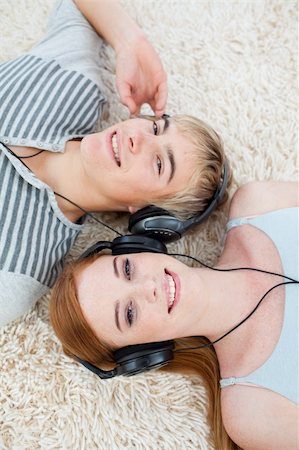 High angle of couple of teenagers listening to music  on th floor Stock Photo - Budget Royalty-Free & Subscription, Code: 400-04199097